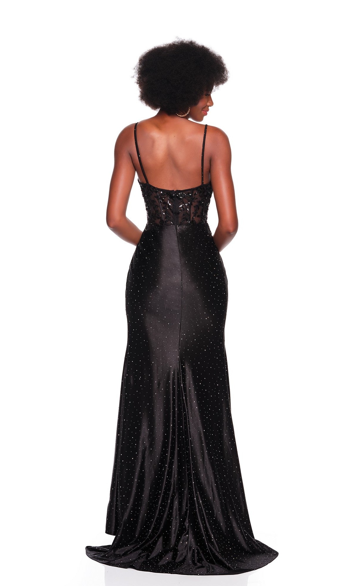 Woman wearing the Dave and Johnny 12806 long black prom dress with thin straps, semi-sheer lace back, and floor-length skirt, standing against a white background, shown from behind.